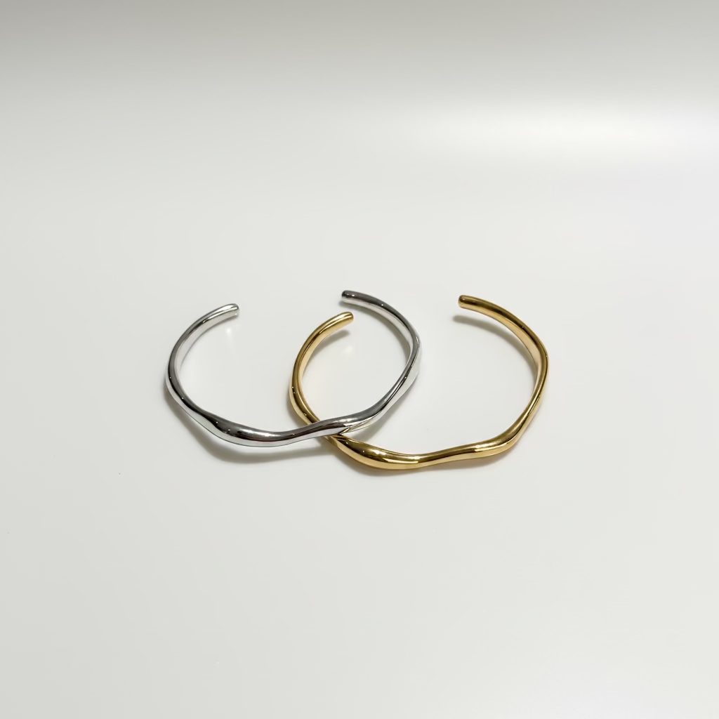 Two gold and silver bangles on a marble surface