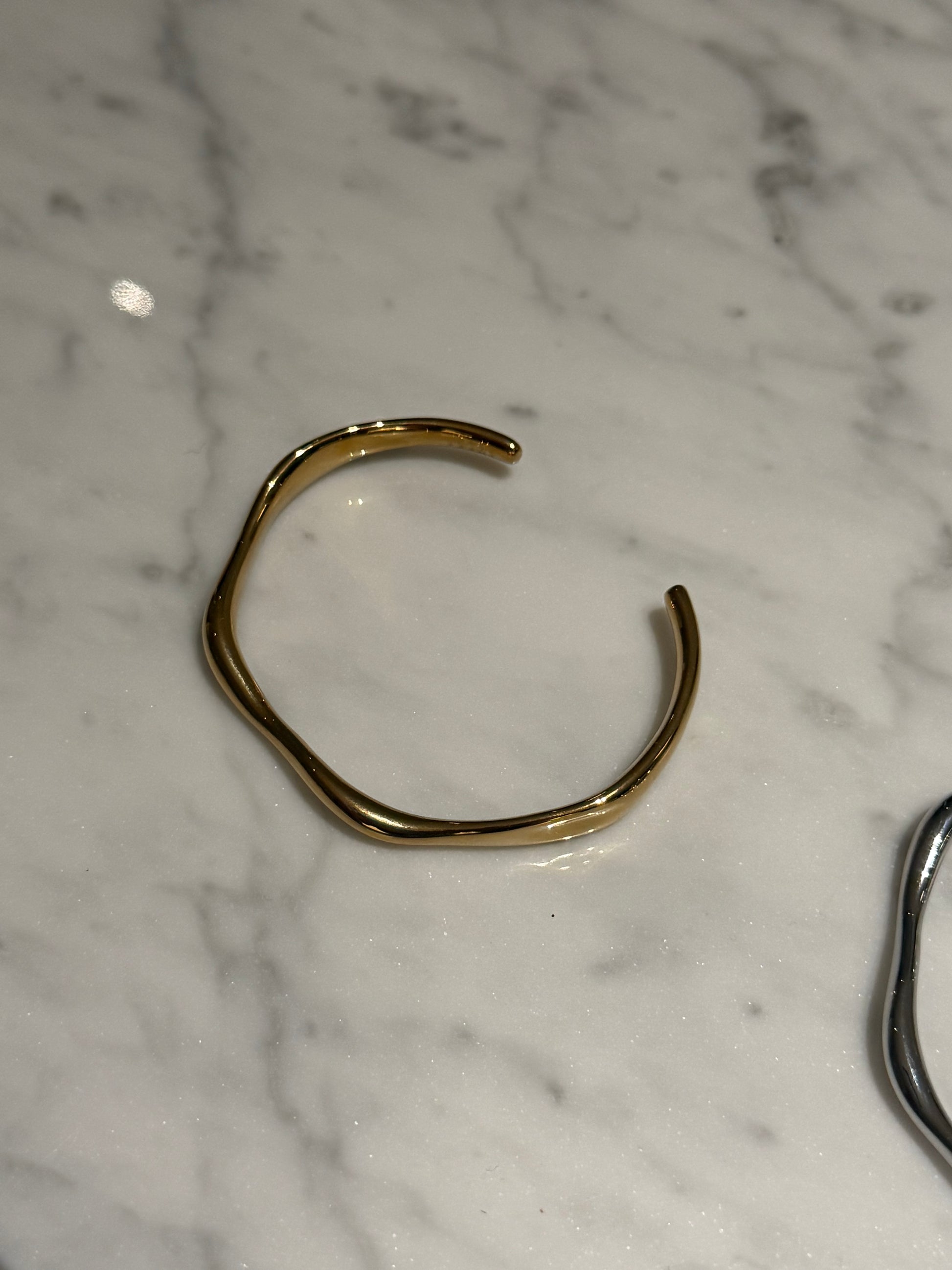 Gold cuff on marble surface