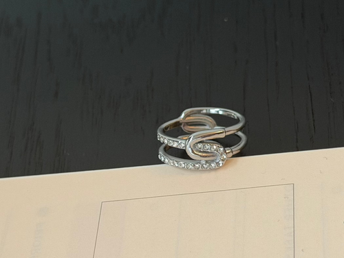 Silver ring on a planner with text on a dark surface
