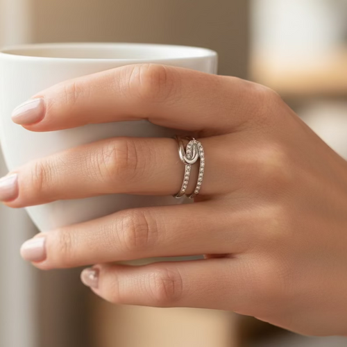 Close-up of a hand wearing a silver ring with a blurred background