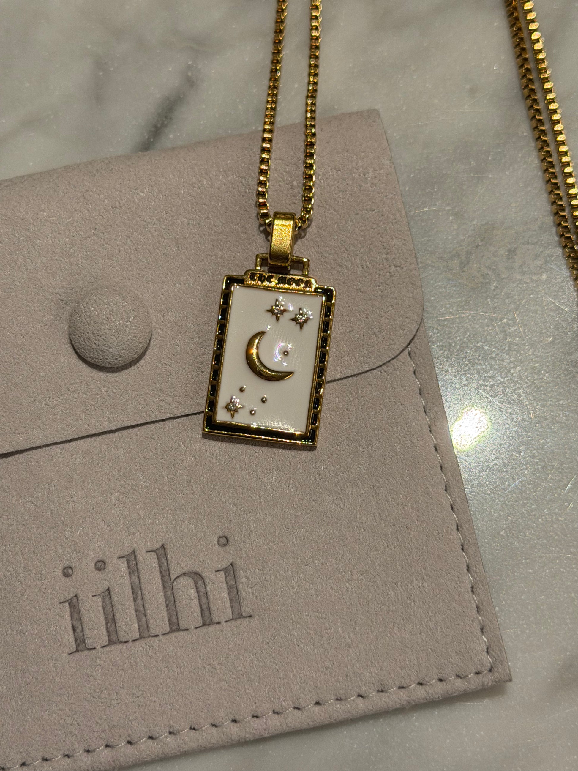 Gold necklace with The Moon tarot pendant with 'iilhi' branding.